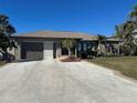 Single-story home with a two-car garage and palm trees at 3761 Peace River Dr, Punta Gorda, FL 33983