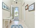 Bright entryway with tiled floor, white table, and coastal decor at 6139 Grand Cypress Blvd, North Port, FL 34287