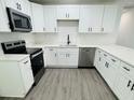 Modern kitchen with white cabinets, quartz countertops, and stainless steel appliances at 1100 Belkton Ave, Port Charlotte, FL 33948