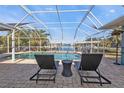 Relaxing screened-in pool area with lounge chairs and a view of the canal at 18500 Ohara Dr, Port Charlotte, FL 33948