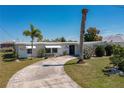 Single story home with circular driveway and mature palm tree at 217 W Tarpon Nw Blvd, Port Charlotte, FL 33952