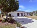 One-story home with a white exterior, landscaping, and a two-car garage at 2219 Bengal Ct, Punta Gorda, FL 33983