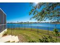 Landscaped backyard with lake view and a black metal fence at 24337 Contra Costa Ln, Punta Gorda, FL 33955