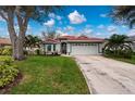 Single-story home with red tile roof, attached garage, and landscaped yard at 3191 Village Ln, Port Charlotte, FL 33953