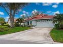 Single-story home with red tile roof, attached garage, and landscaped yard at 3191 Village Ln, Port Charlotte, FL 33953