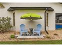 Relaxing patio with two blue chairs and a green umbrella at 7424 S Moss Rose, Punta Gorda, FL 33955