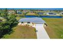 Single-story house with gray roof and white garage, situated on a large lot near water at 102 Annapolis Ln, Rotonda West, FL 33947