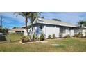 Another view of the home's exterior, highlighting landscaping at 10454 Waterford Ave, Englewood, FL 34224