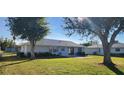 Backyard view with a patio and mature trees providing shade at 10454 Waterford Ave, Englewood, FL 34224