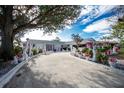 Mature trees and unique yard art enhance this home's exterior at 115 Sw Seville Sw Pl, Port Charlotte, FL 33952