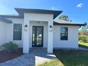 Modern front entrance with black double doors and stone walkway at 12547 Trinity Ave, Port Charlotte, FL 33953