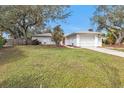 Front view of a single-story home with a lush green lawn at 21190 Midway Blvd, Port Charlotte, FL 33952