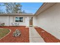 Front entryway with walkway, landscaping, and a wooden door at 21190 Midway Blvd, Port Charlotte, FL 33952