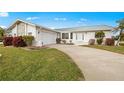 White single-story home with green metal roof, attached garage, and landscaped lawn at 2218 Cassino Ct, Punta Gorda, FL 33950