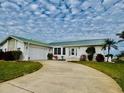 Single story home with a green metal roof and driveway at 2218 Cassino Ct, Punta Gorda, FL 33950