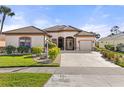 One-story house featuring a tile roof, three-car garage, and neatly landscaped front yard at 2408 Silver Palm Rd, North Port, FL 34288