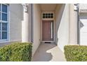 House entrance with brown door, columns, and neatly trimmed shrubs at 24356 Westgate Blvd, Punta Gorda, FL 33980