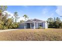 Single-story house with gray siding, a two-car garage, and a landscaped lawn at 2784 Dode Ave, North Port, FL 34288