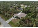 House nestled in a wooded neighborhood with a screened enclosure at 3953 Vehlin St, North Port, FL 34286