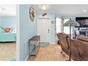 Inviting foyer with nautical decor, a wooden table, tiled floor, and a glimpse into the Primary bedroom at 4297 Nettle Rd, Port Charlotte, FL 33953