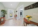 Bright entryway with tile flooring, console table, and plant decor at 7083 Mifflin St, Englewood, FL 34224