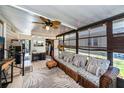 Relaxing sunroom with wicker furniture and tropical plants at 805 Manchester Ct, Englewood, FL 34223