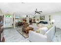 Bright living room with tile floors, neutral paint, and an open floor plan leading to the kitchen at 8242 Lakeside Dr, Englewood, FL 34224