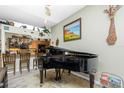 Stylish piano in living room with decor on top of kitchen wall and unique giraffe wall art at 8242 Lakeside Dr, Englewood, FL 34224