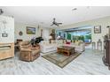 Spacious living room featuring tile floors, comfortable seating, and natural light streaming through windows at 8242 Lakeside Dr, Englewood, FL 34224