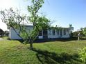 Side view of the house with a large tree and grassy yard at 120 Rodgers Ne Ave, Port Charlotte, FL 33952