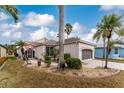 Single-story home with palm trees and well-manicured lawn at 10214 Windsong Rd, Punta Gorda, FL 33955