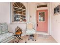 Quaint front porch with seating and a coral door at 10214 Windsong Rd, Punta Gorda, FL 33955