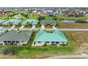 Aerial image showing multiple homes in a community with green roofs and a golf course at 1551 Atares Dr # 112, Punta Gorda, FL 33950