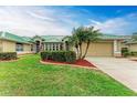 Exterior view of a charming house with a green metal roof, two-car garage, and manicured lawn at 1551 Atares Dr # 112, Punta Gorda, FL 33950
