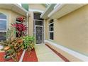 Front entry with a screened door, lush landscaping, and a walkway at 1551 Atares Dr # 112, Punta Gorda, FL 33950