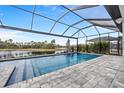 Resort-style pool with a covered patio overlooking a lake at 19916 Bridgetown Loop, Venice, FL 34293