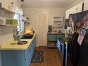 Charming kitchen with teal cabinets and a yellow countertop at 2488 Warne St, Port Charlotte, FL 33952