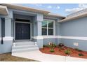 Home's entryway with double doors and landscaping at 27 Meadowlark Ln, Placida, FL 33946