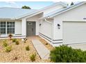 Front view of house showcasing gray door and garage at 28434 Sabal Palm Dr, Punta Gorda, FL 33982