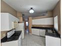 Bright kitchen featuring white cabinets, and modern appliances at 3739 Eldron Ave, North Port, FL 34286