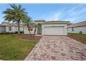 Single-story home with a two-car garage and landscaped front yard at 6049 Grand Cypress Blvd, North Port, FL 34287