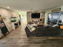 Spacious living area featuring a large sectional sofa and stone accent wall at 258 Beeney Se Rd, Port Charlotte, FL 33952
