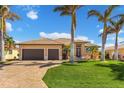 Tan house with brown garage doors and a paved driveway at 1002 Messina Dr, Punta Gorda, FL 33950