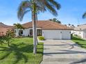 White two-story house with tile roof, three-car garage, and lush landscaping at 11 Sabal Dr, Punta Gorda, FL 33950