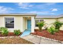 House entrance with light blue door, landscaping, and walkway at 13284 Buckett Cir, Port Charlotte, FL 33981