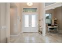 Bright and airy foyer with tile floors and access to an office at 1406 Mediterranean Dr, Punta Gorda, FL 33950