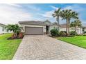 House exterior featuring a paved driveway and a well-maintained lawn at 15169 Spanish Point Dr, Port Charlotte, FL 33981