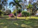 Beautiful front yard with mature palm trees and vibrant bougainvillea bushes adds color and character to the property at 21217 Knollwood Ave, Port Charlotte, FL 33952