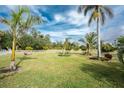 Expansive backyard with lush tropical landscaping and white fence at 24434 Rio Togas Rd, Punta Gorda, FL 33955