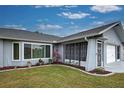 House exterior features gray paint, mature landscaping, and a screened porch at 2798 Rock Creek Dr, Port Charlotte, FL 33948